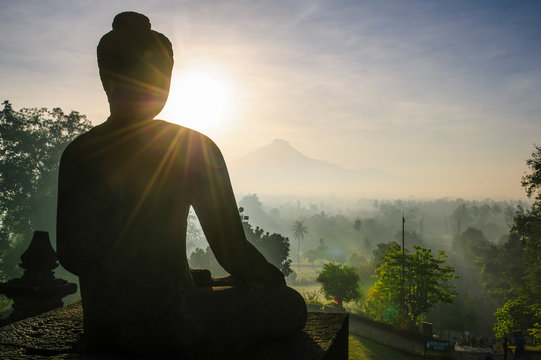 Indonesia, Java, Borobudur Temple Complex, sitting Buddha in backlight