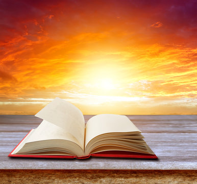 Open book on table and sun sky