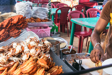 Male hand of a cook cooking seafood outdoors in a street market in Colombo, Sri Lanka