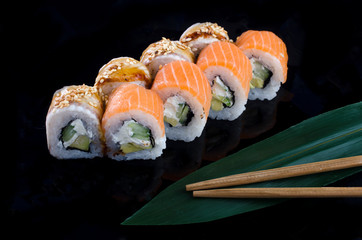 sushi roll with salmon and eel on black background