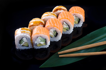 sushi roll with salmon and eel on black background