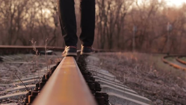 Man walking along the rail trying to keep his balance