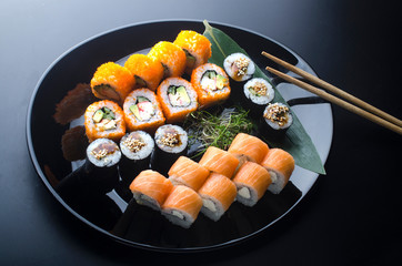 sushi set with different rolls on a black plate