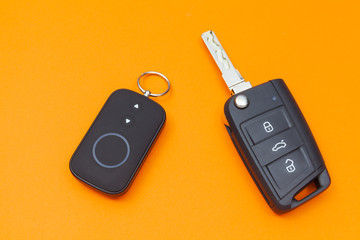 Opened Car Key with Remote Control on an orange background, top view