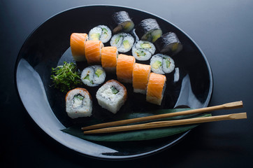 sushi set with different rolls on a black plate