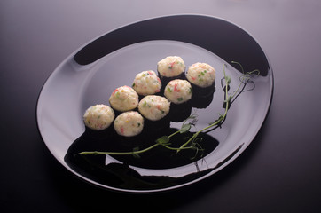 hot sushi rolls with melted cheese in a black plate