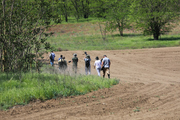Group of unidentifiable photographers and birdwatchers looking for birds. Wildlife photography