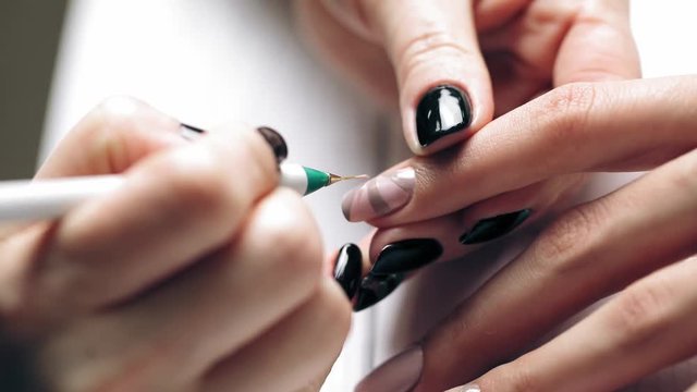 Women paints nails.Manicure Nail Art close up. Beautiful Nail Art Manicure. Nail designs with decoration.Manicure nail paint.