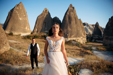 stylish couple bride and groom among the peaks of the mountains