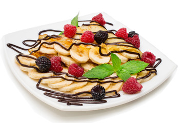 homemade crepes with chocolate cream, banana and blueberries on white background. pancakes