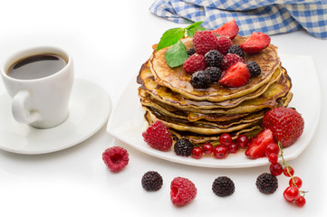 Delicious pancakes with berries and maple syrup on a white background