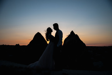 Silhouette couple in love and mountains in the light of sunset