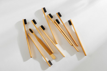 Wooden eco bamboo toothbrushes with black bristle on white background. Sustainable lifestyle. Zero waste concept.