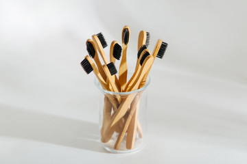 Eco friendly bamboo toothbrushes with black bristle, bathroom essentials on white background. Zero waste, plastic free concept.