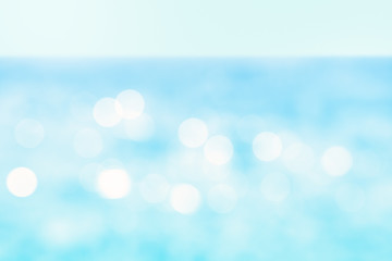 Abstract sea background. Defocused blue water surface with shiny bokeh lights. Blurred summer...