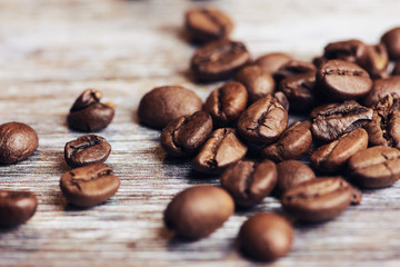 roasted brown coffee beans on a brown wooden surface, macro color photo
