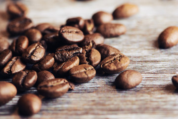 roasted brown coffee beans on a brown wooden surface, macro color photo