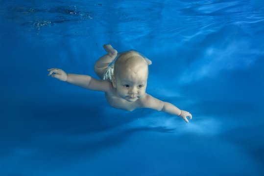 Small child learns to swim underwater in a pool, Odessa, Ukraine, Europe