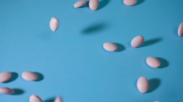 tablets fall on a blue background and roll