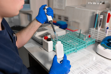 laboratory assistant analyzing a blood sample using micropipette