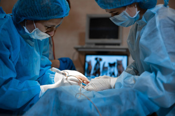 Closeup surgeon hands in bit bloody white gloves make operation