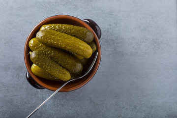 Pickled gherkins with mustard and garlic on a stone rusty background.