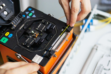 worker comunicate fiber optic cable at opto box. installing new network equipment