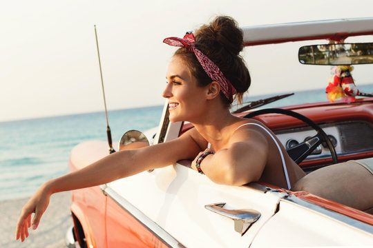 Beautiful and happy woman inside retro cabriolet car