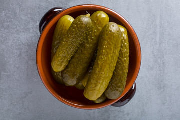 Pickled gherkins with mustard and garlic on a stone rusty background.