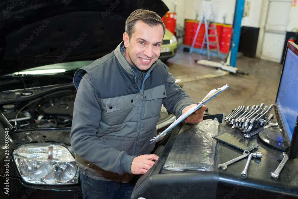 Wall mural mechanic at car at workshop