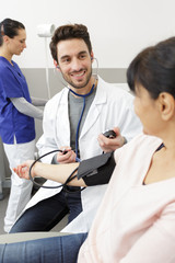 doctor performing blood pressure check on female patient