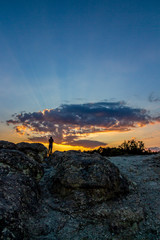 Rear view of unrecognizable male photographer taking pictures of the sunset over the Stone Mushrooms near Beli Plast village, Kardzhali Municipality, Bulgaria