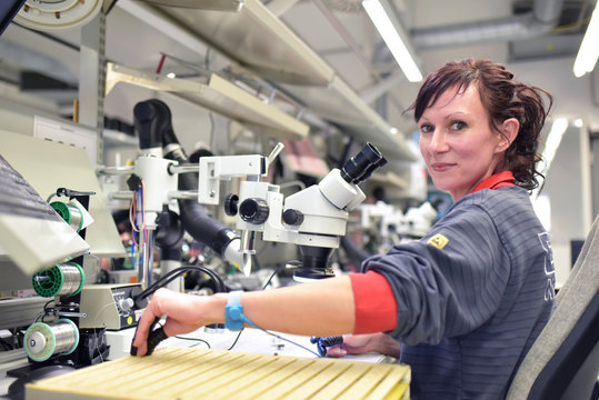Woman working on quality control in the manufacturing of circuit boards for the electronics industry