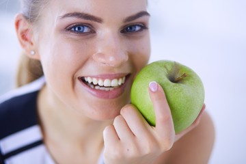 Close up portrait of healthy smiling woman with green apple.