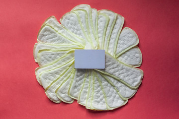 Feminine hygiene pad with blank white paper on red background