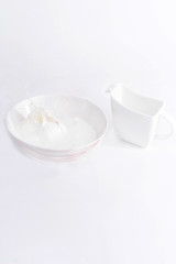 Milk splashed on a large bowl and saucer on white background, isolated