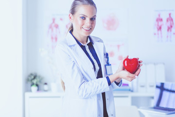 A doctor with stethoscope examining red heart, isolated on white background