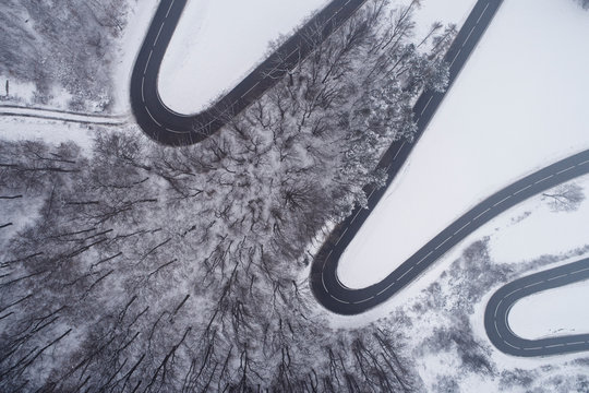Austria, Wienerwald, winding road in snow-covered landscape, aerial view