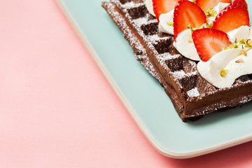 Chocolate waffles with strawberries and whipped cream