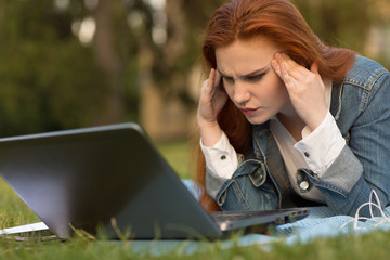 Young female student using gadgets on campus