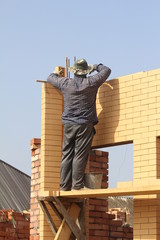 The builder Mason lays the yellow bricks of the building.