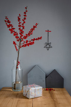 Wrapped present, decoration and twig of holly in vase