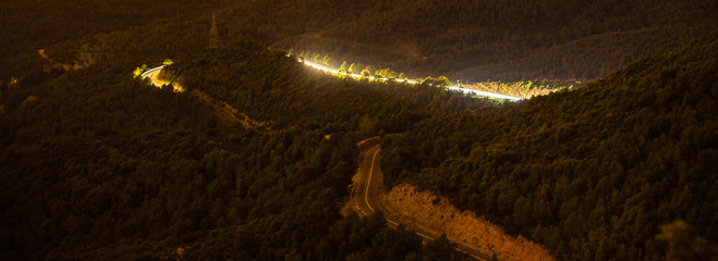 Road between forest contrasted by light painting 