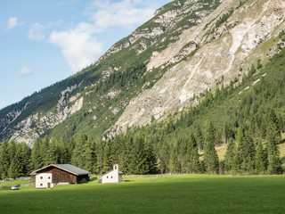 Fototapeta na wymiar Alpine dairy farm in a mountain landscape in the Pinnistal, a valley that branches off from the Stubai valley, Stubai Alps, Tyrol, Austria, Europe