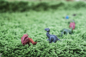 Toy dinosaurs in high grass miniature wild life