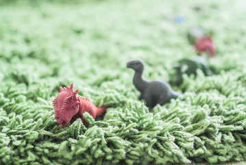 Toy dinosaurs in high grass miniature wild life