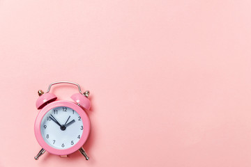 Ringing twin bell vintage classic alarm clock Isolated on pink pastel colorful trendy background....