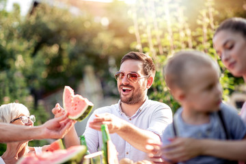 Obraz premium Family having a lunch in their garden in summer