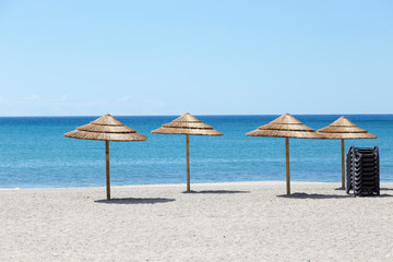 Beautiful palm tree sun umbrellas on the beach