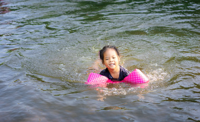 little asian girl swimming in the river